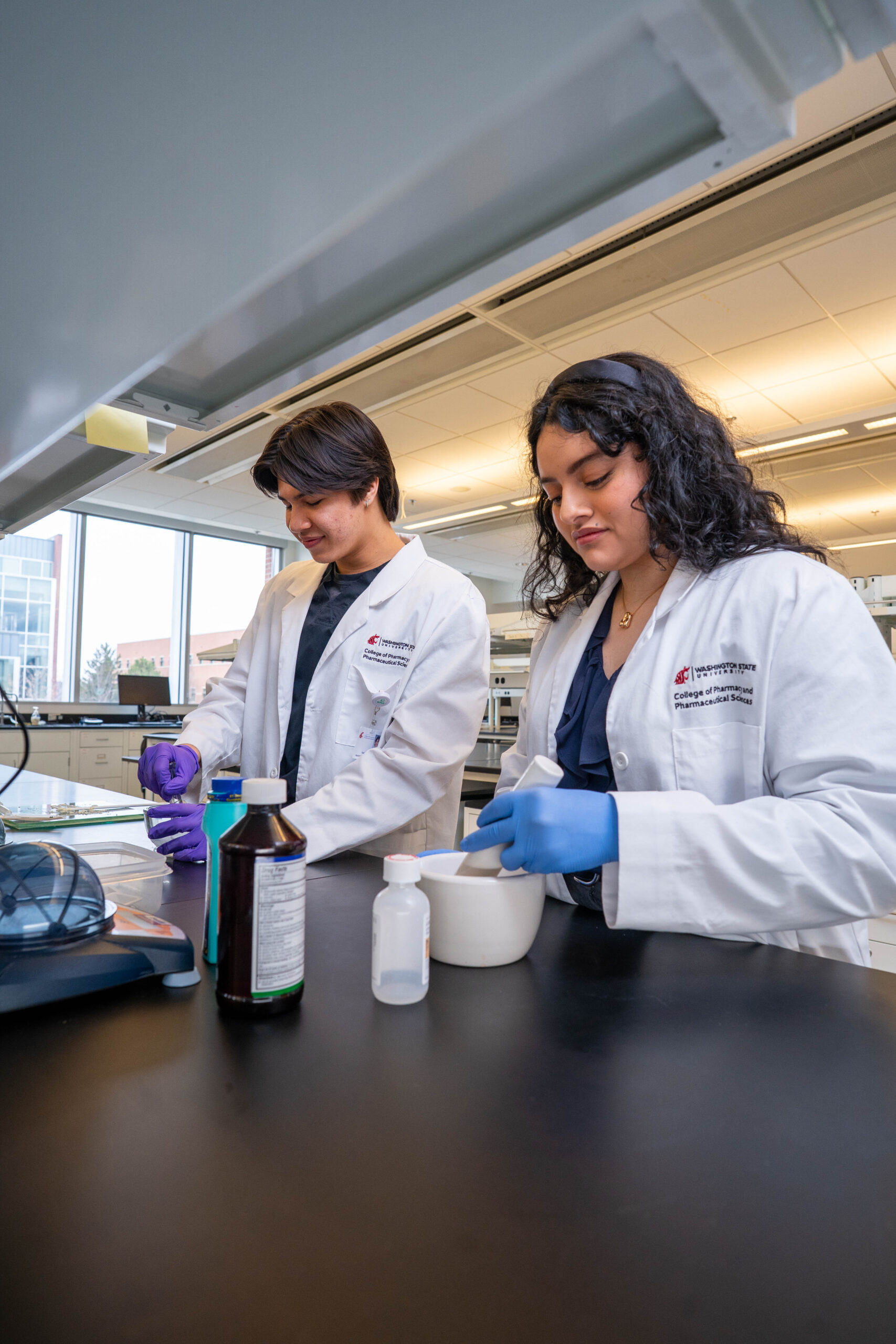 Two pharmacy students practice compounding medications