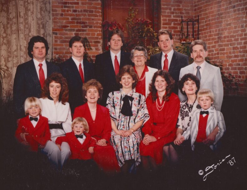 A family photo of Janet Ruth Warren with her seven children, three daughter-in-laws, and three grandchildren. The photo was taken in 1987.