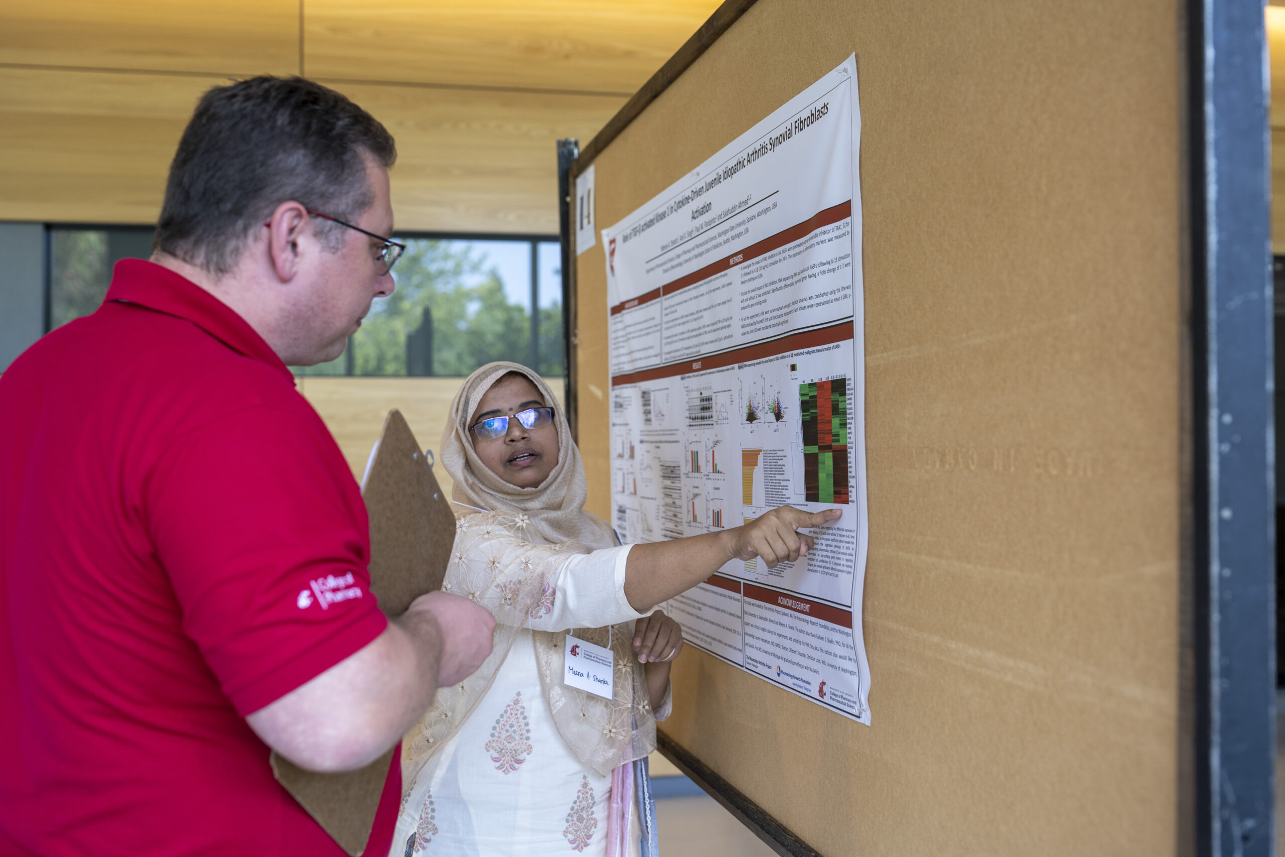 PhD student Meena Shanta explains her research using a poster as a visual aid during Research Day