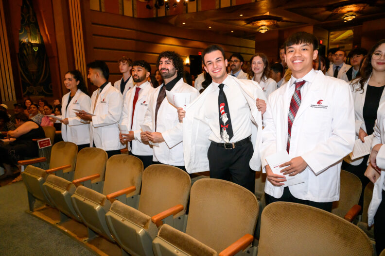 Class of 2030 WSU Doctor of Pharmacy students in their white coats at the Fox Theater.