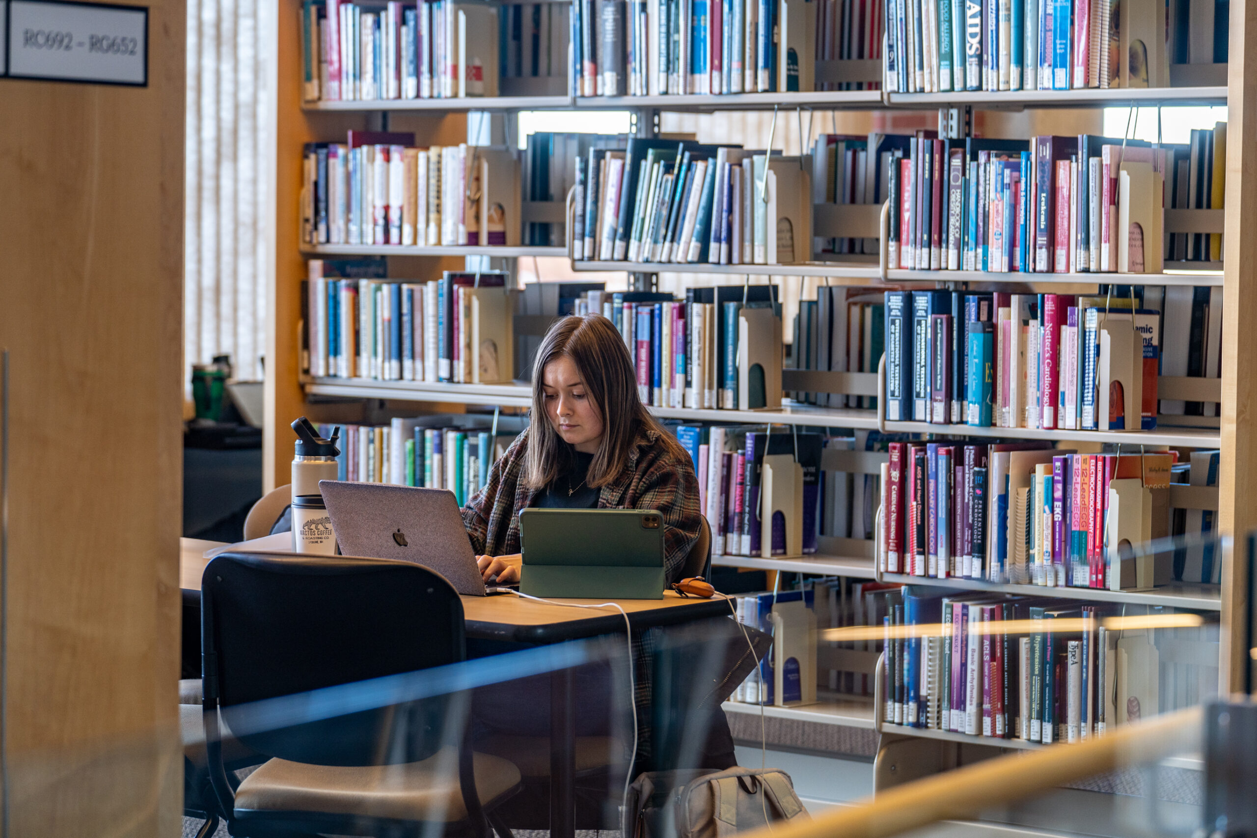 student working on laptop in library
