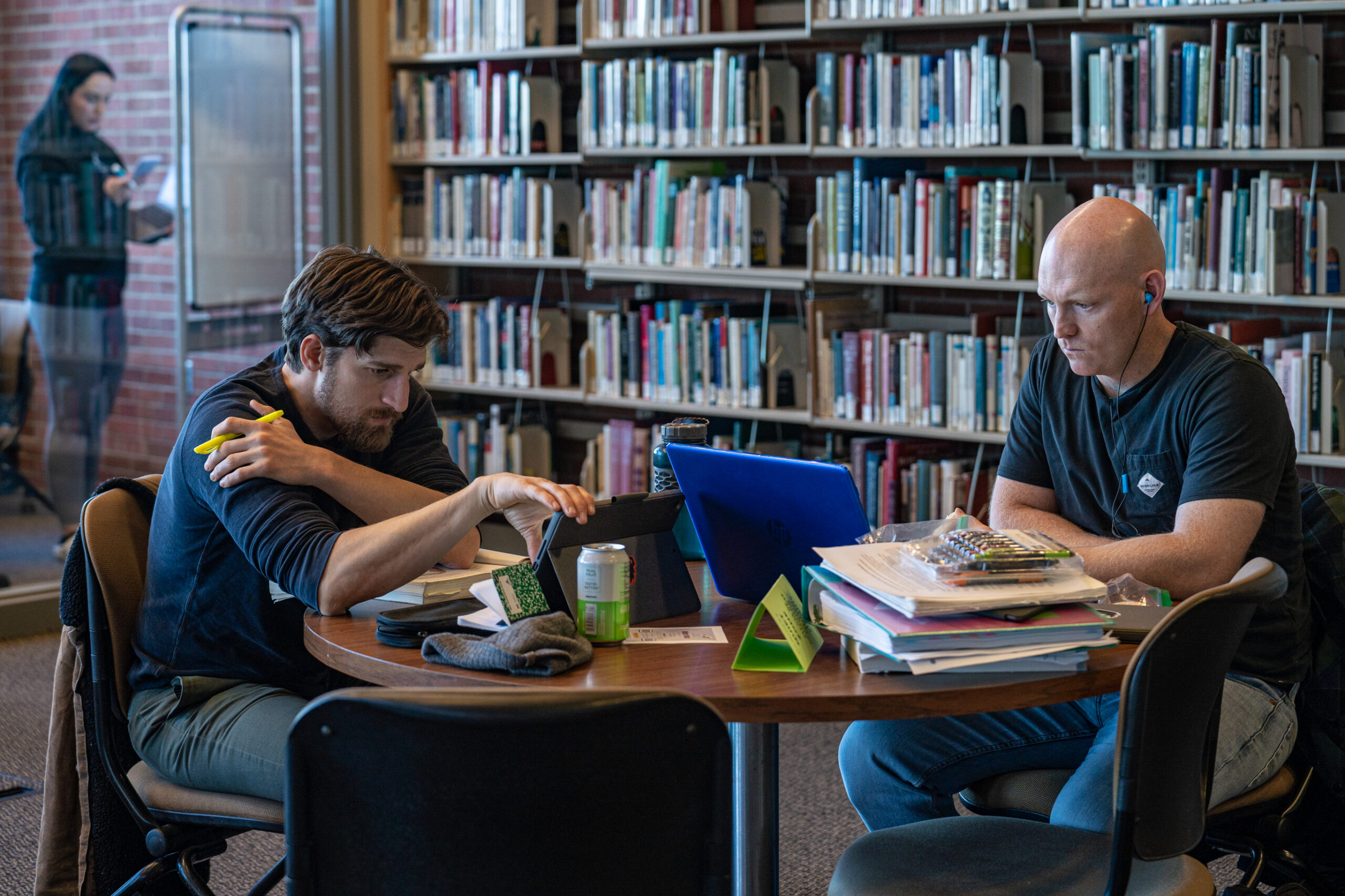 two students studying in the library sitting across from each other