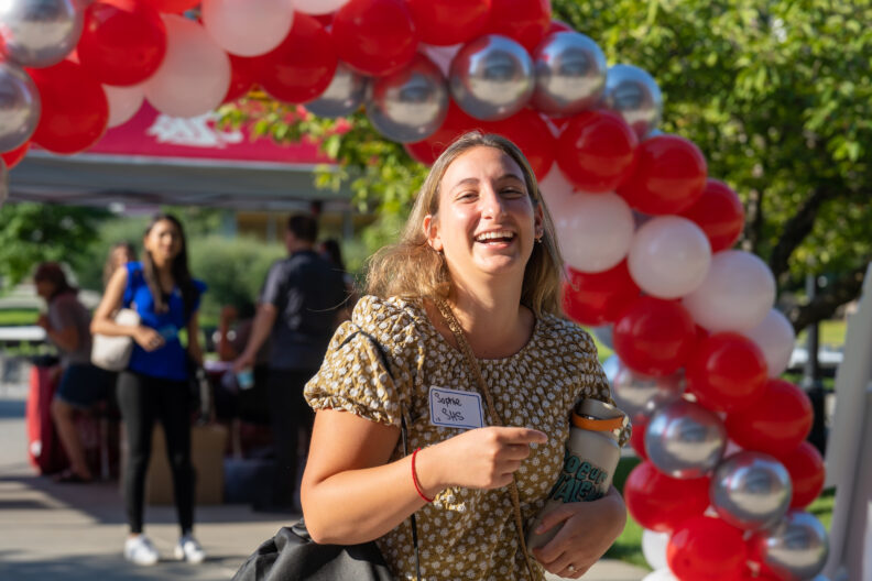 student attending campus orientation smiling at the camera