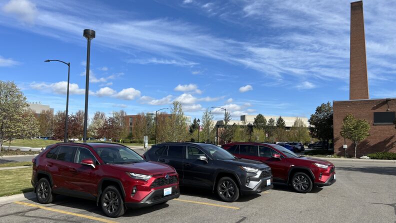 WSU Spokane rental vehicle fleet. Two red toyota RAV4's with a gray one in the middle. Three total