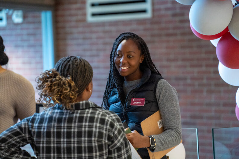 Student interacting with a WSU Employee during a campus barbecue event
