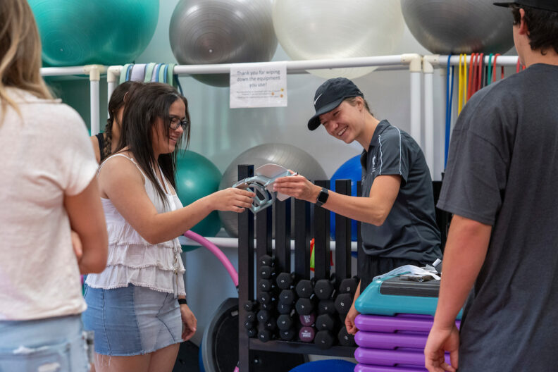 Students laughing with exercise equipment.