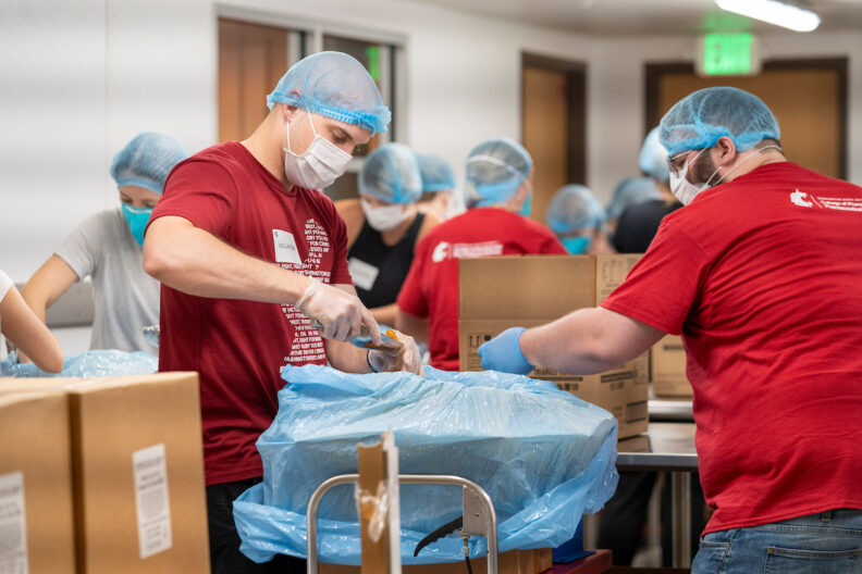 Student packaging food in red shirts