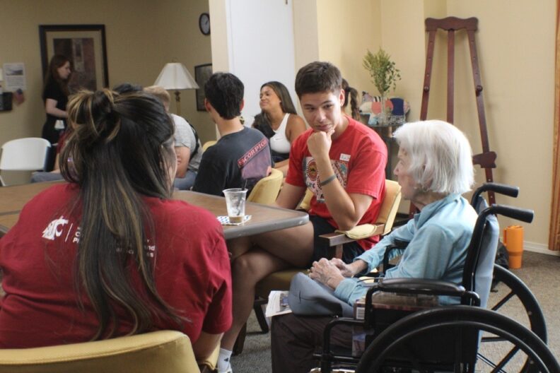 Students visit with residents at Touchmark, a senior living facility in Spokane.