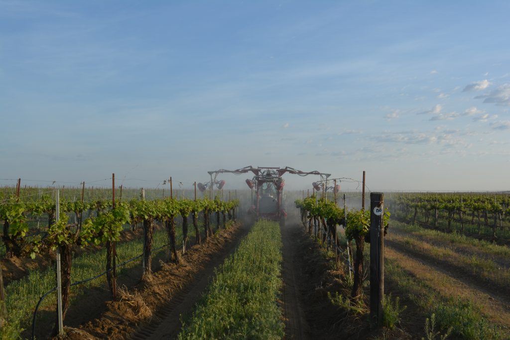 Student in a computer lab wearing a virtual reality headset and using controllers.