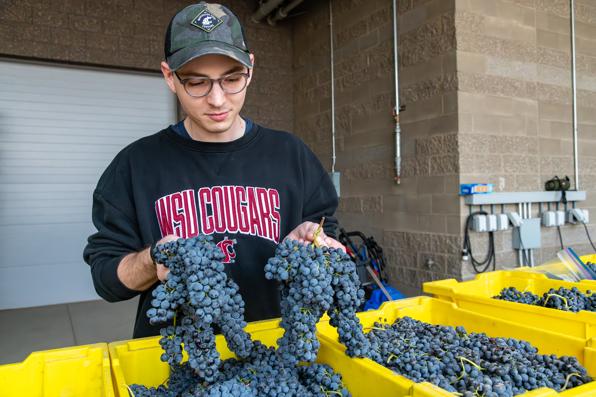 Student in a computer lab wearing a virtual reality headset and using controllers.