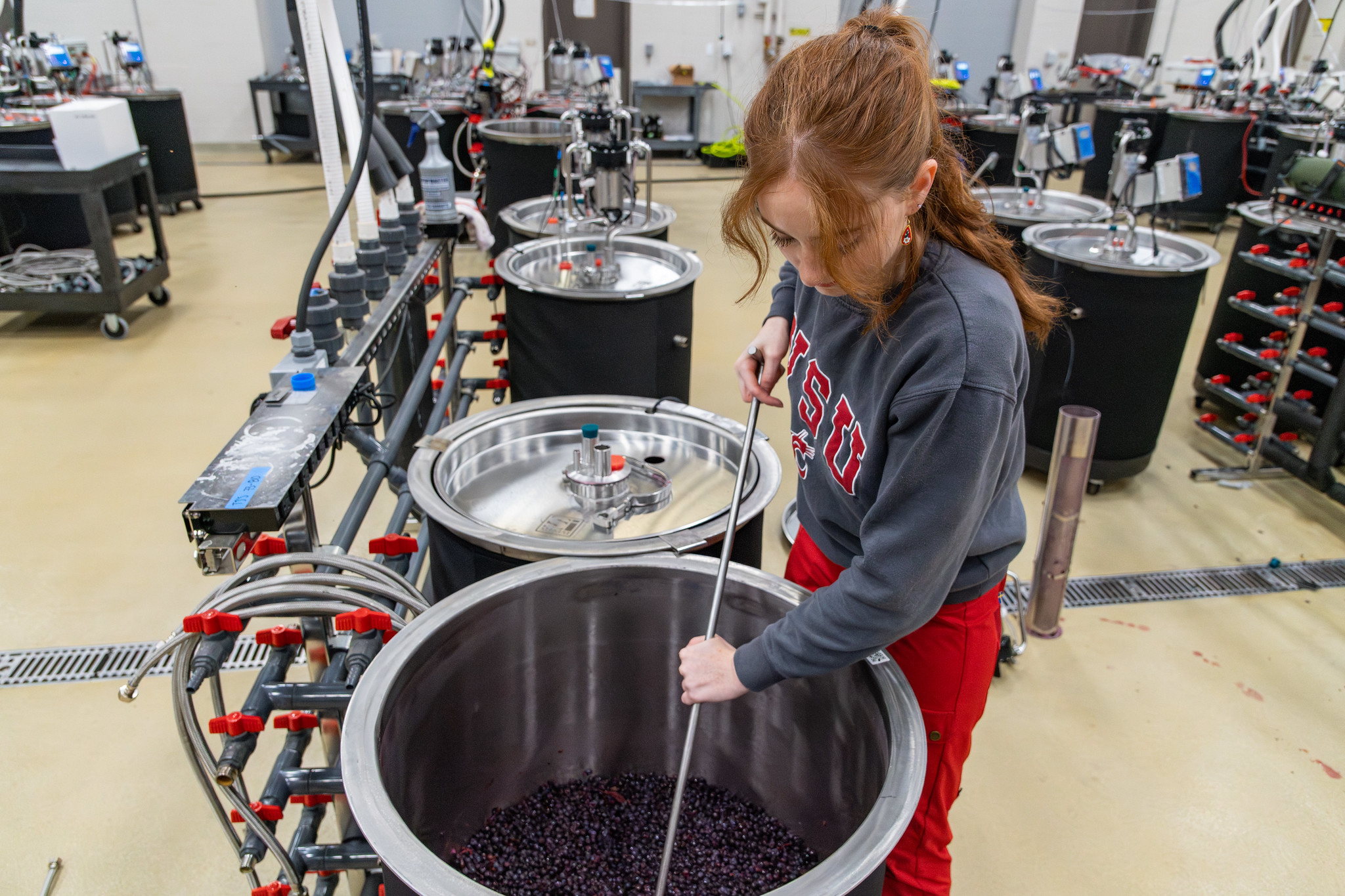 Student in a computer lab wearing a virtual reality headset and using controllers.
