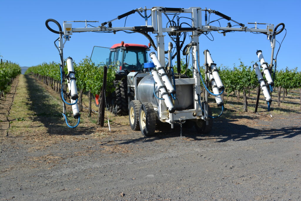 An electrostatic sprayer in a vineyard
