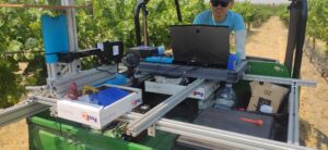 A person drives down a vineyard with a computer and specialized instrumentation to capture images of vineyards