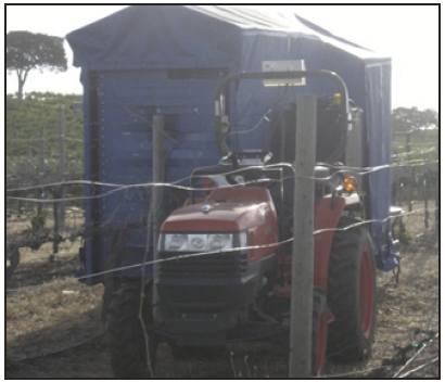 a driverless tractor towing an over-the-row tent-like implement