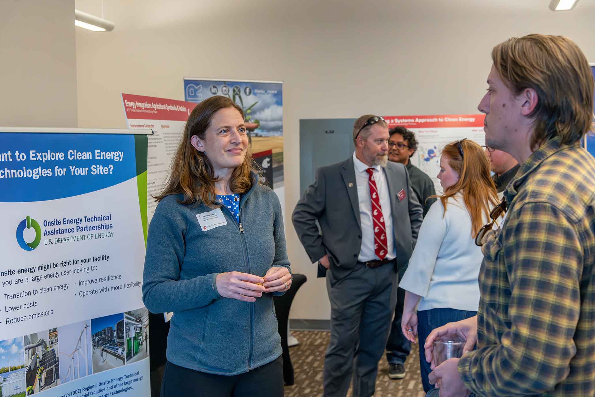 Georgine Yorgey, Senior Research Fellow, CSANR talking to in interested individual. Chad Kruger, INEF Assistant Director for Agriculture, Extension & Outreach is in the background.