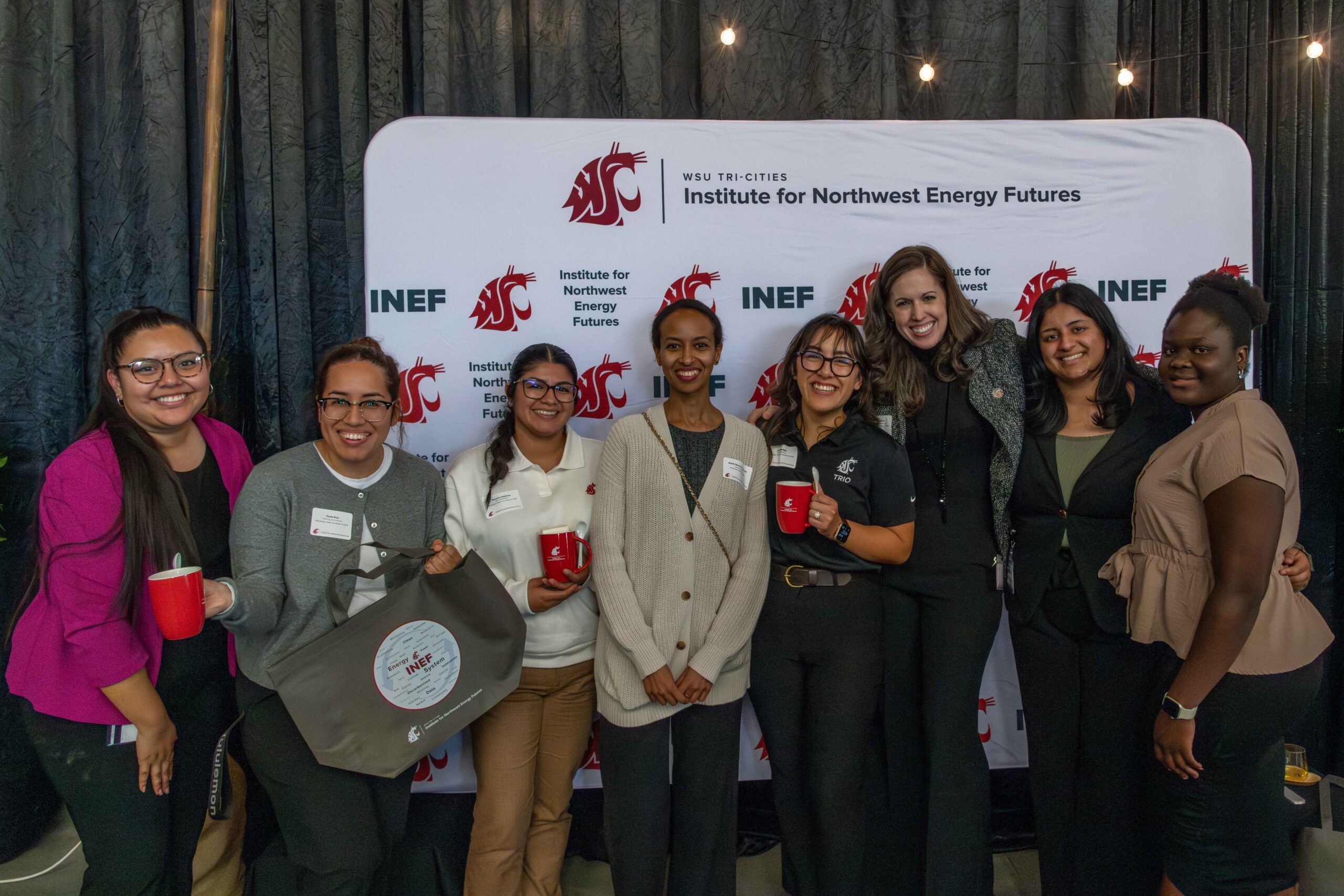 CEAN ambassadors and with Jillian Cadwell, WSU Tri-Cities Research Associate and Civil Engineering Adjunct Professor in front of an INEF step and repeat.