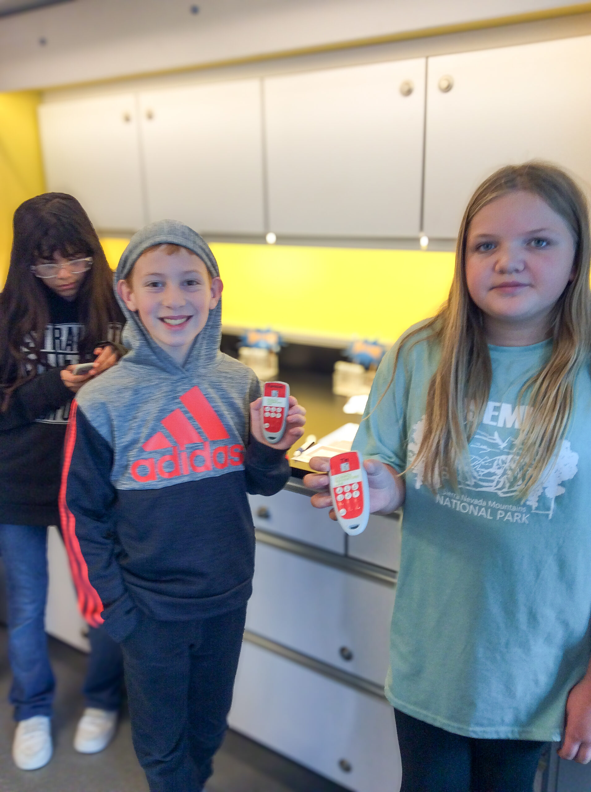 Grade 5 students smiling and holding clickers.