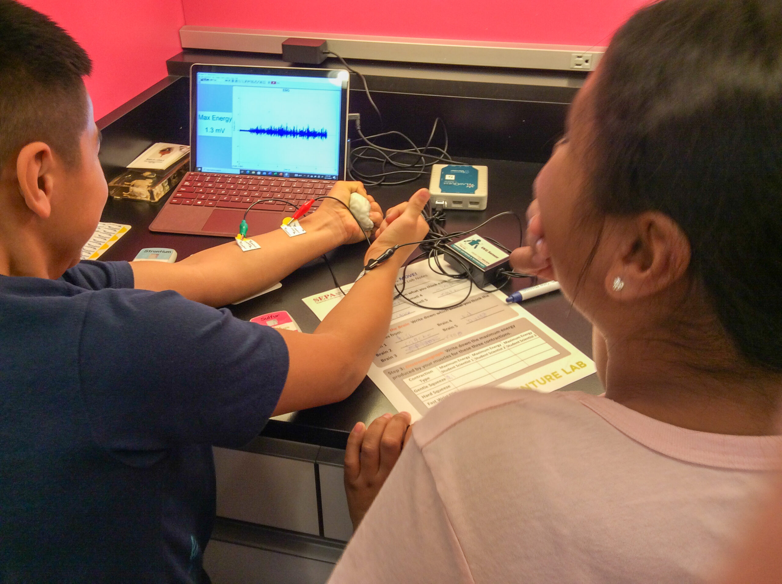 Students recording using an EMG while they flex their muscles.