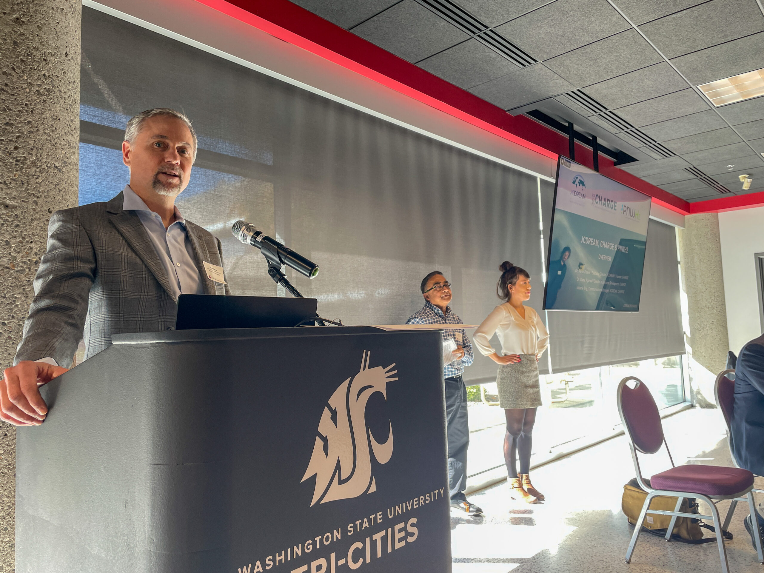JCDREAM's Executive Director Aaron Feaver gives his flash talk before Vishal Agarwal, Director of Business Development, and Melanie Eng, Communications Manager, have a part.