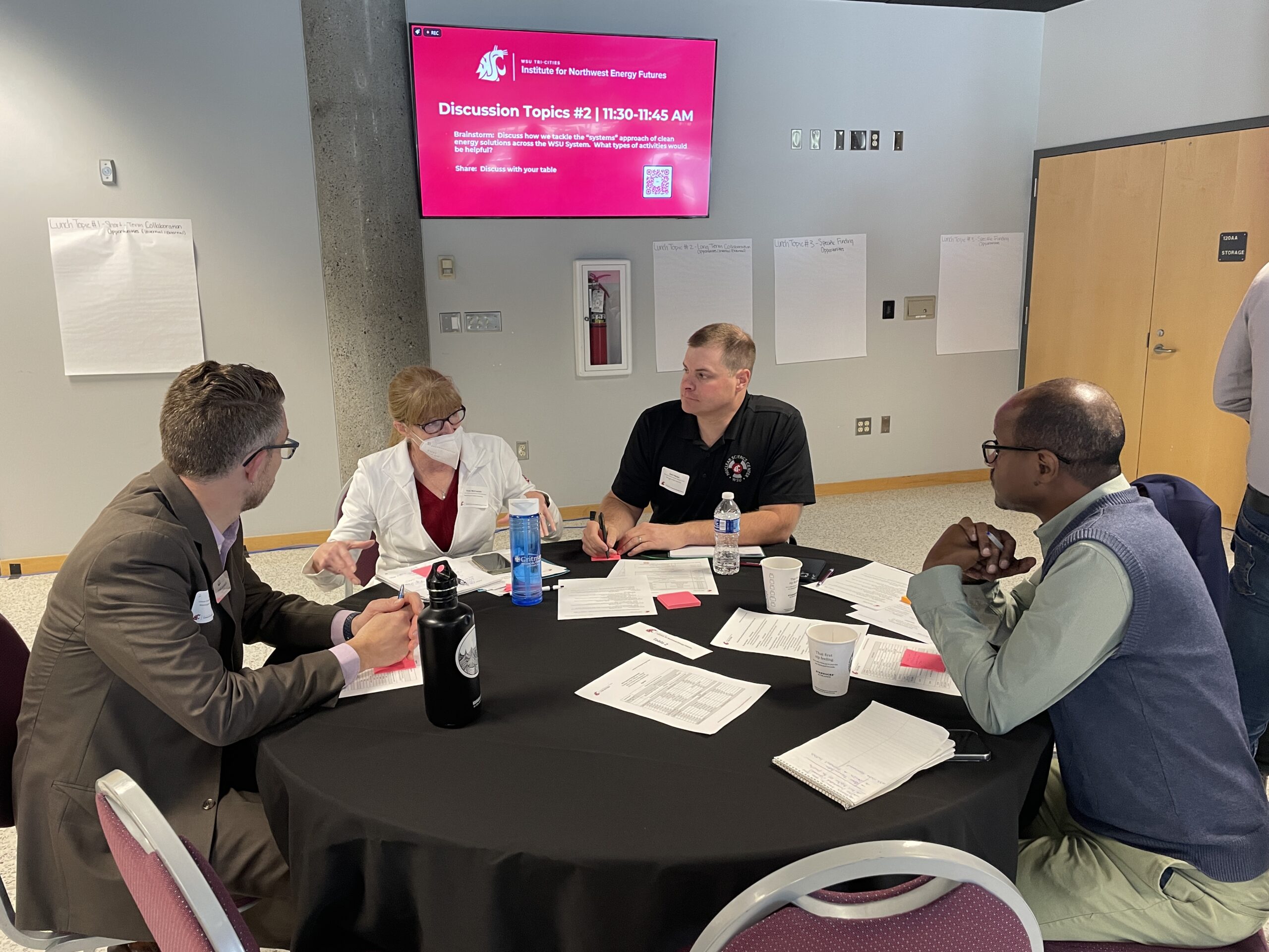 Associate Dean and Director of Extension Vicki McKracken shares a point with Yonas Demissie, INEF Assistant Director of Engineering & Environment, Climate Pollution Reduction Program Manager Joel Creswell, and another individual during the 2024 Energy Summit.