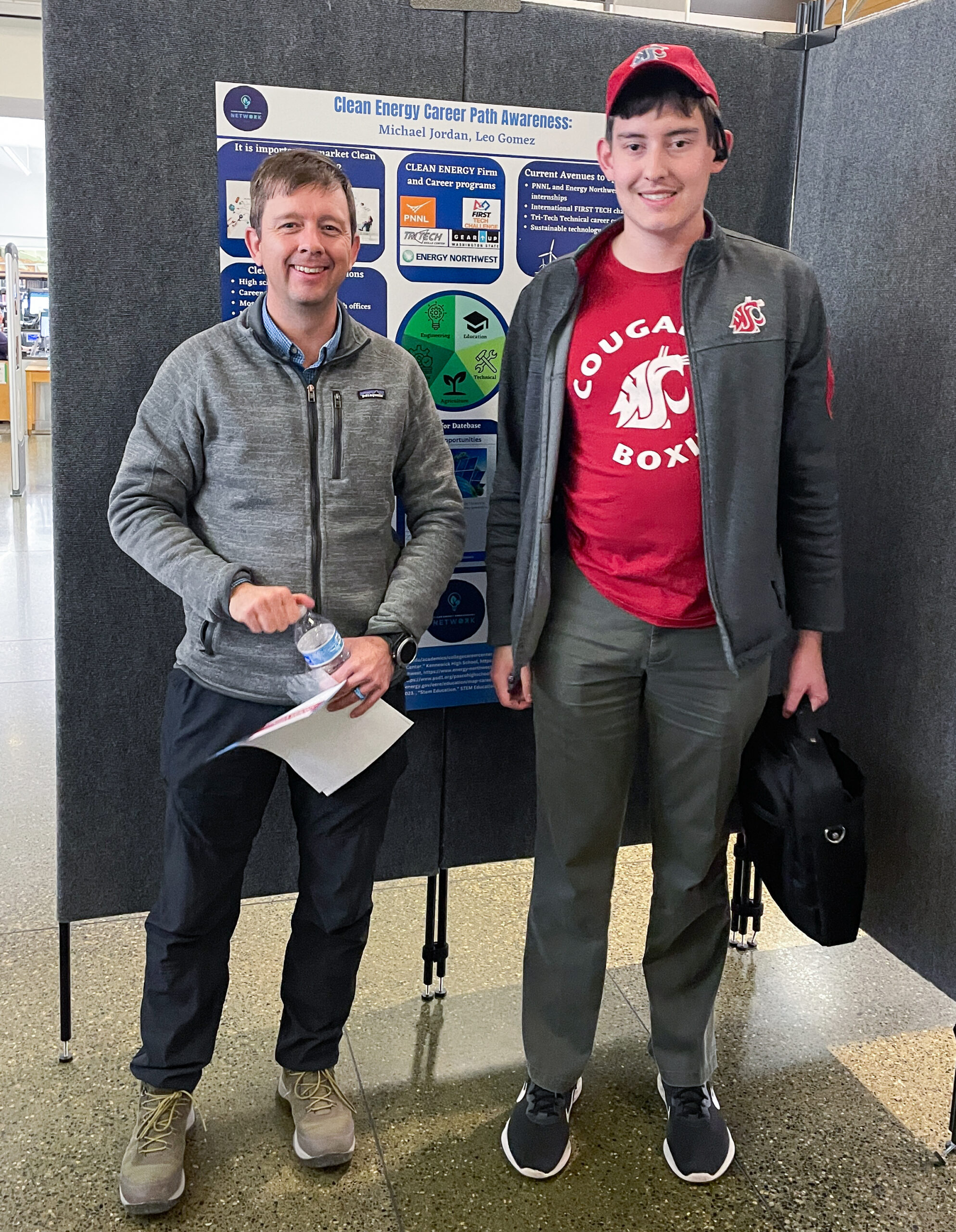 Scott Hanks, PE City of Richland, standing beside WSU CEAN student ambassador Michael Jordan after viewing Michael's poster.
