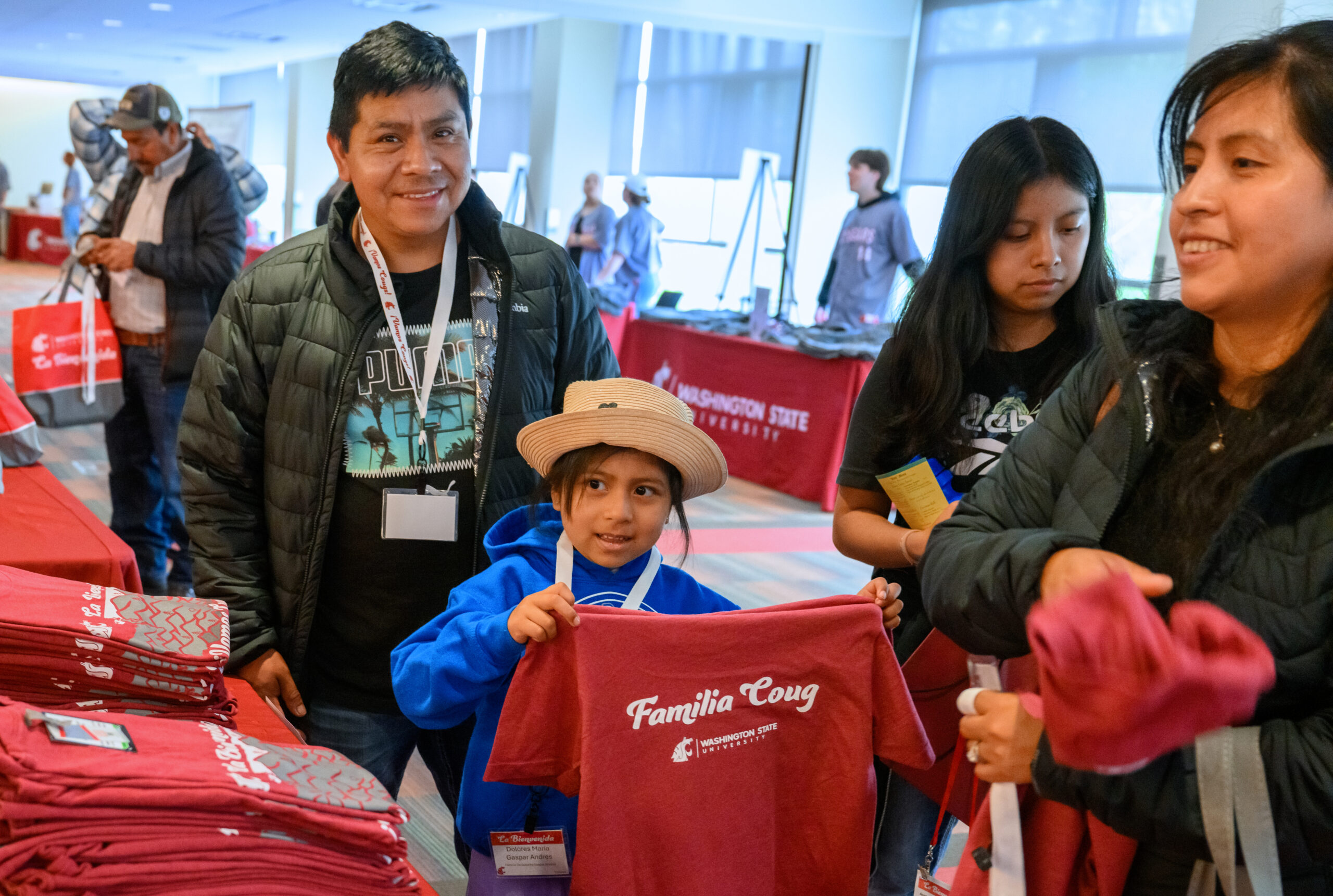 Child holding up familia coug shirt at New Coug Orientation.