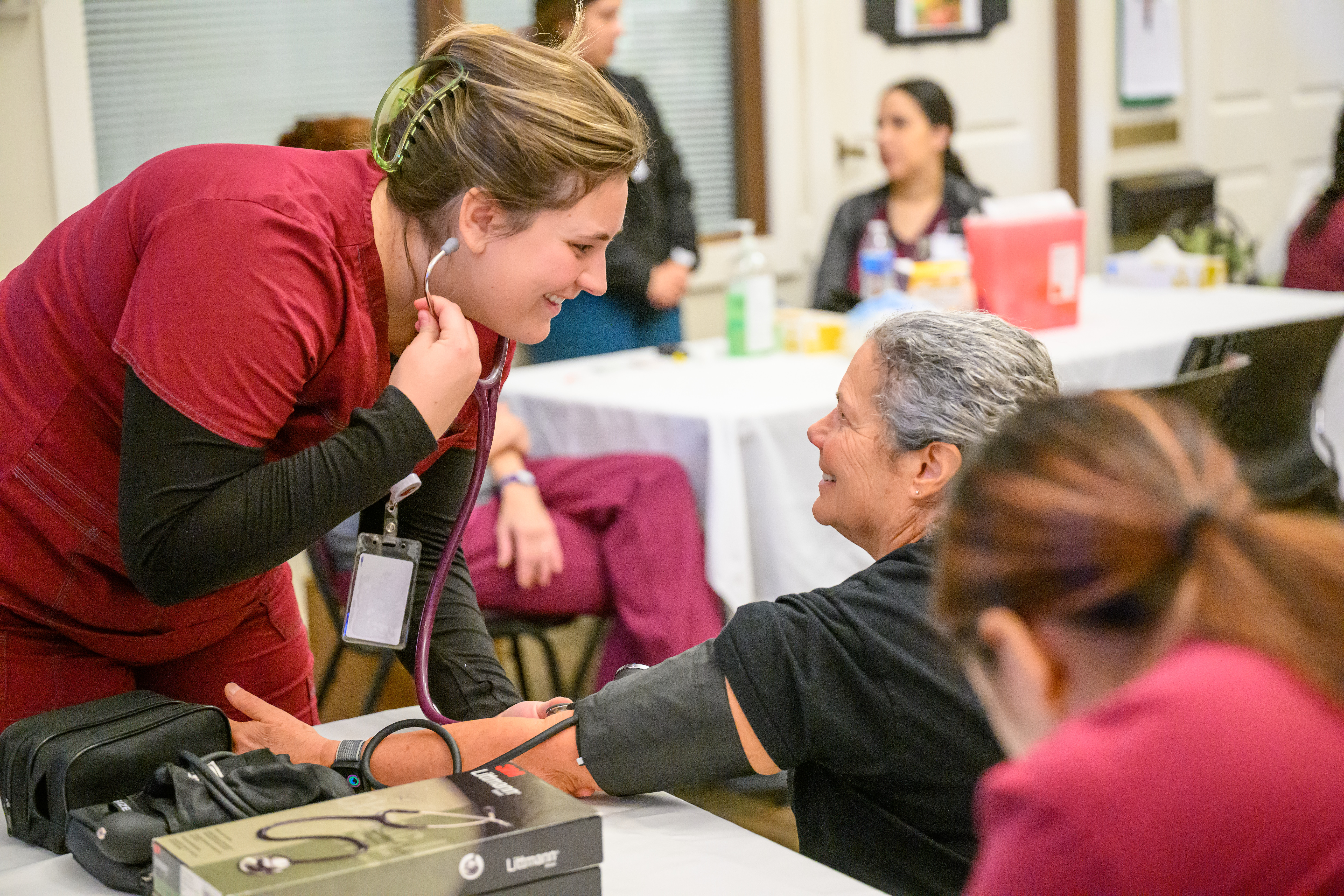 Medical student checking a patient with a stethoscope.