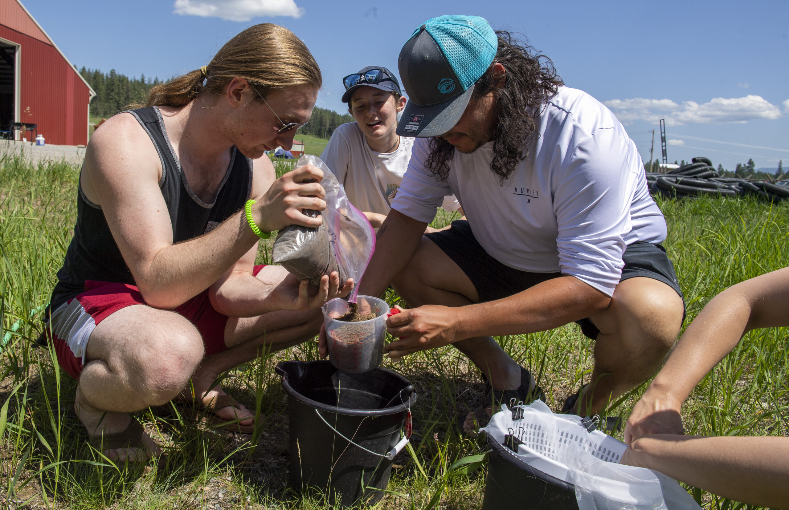 Three people working with soil samples.