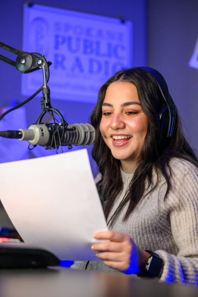 Monica Carrillo-Casas, Murrow Fellow, reading news into a microphone.