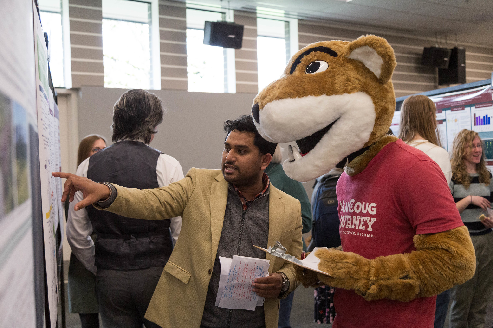 A group of people interacting with Butch, the WSU mascot, in an open indoor space