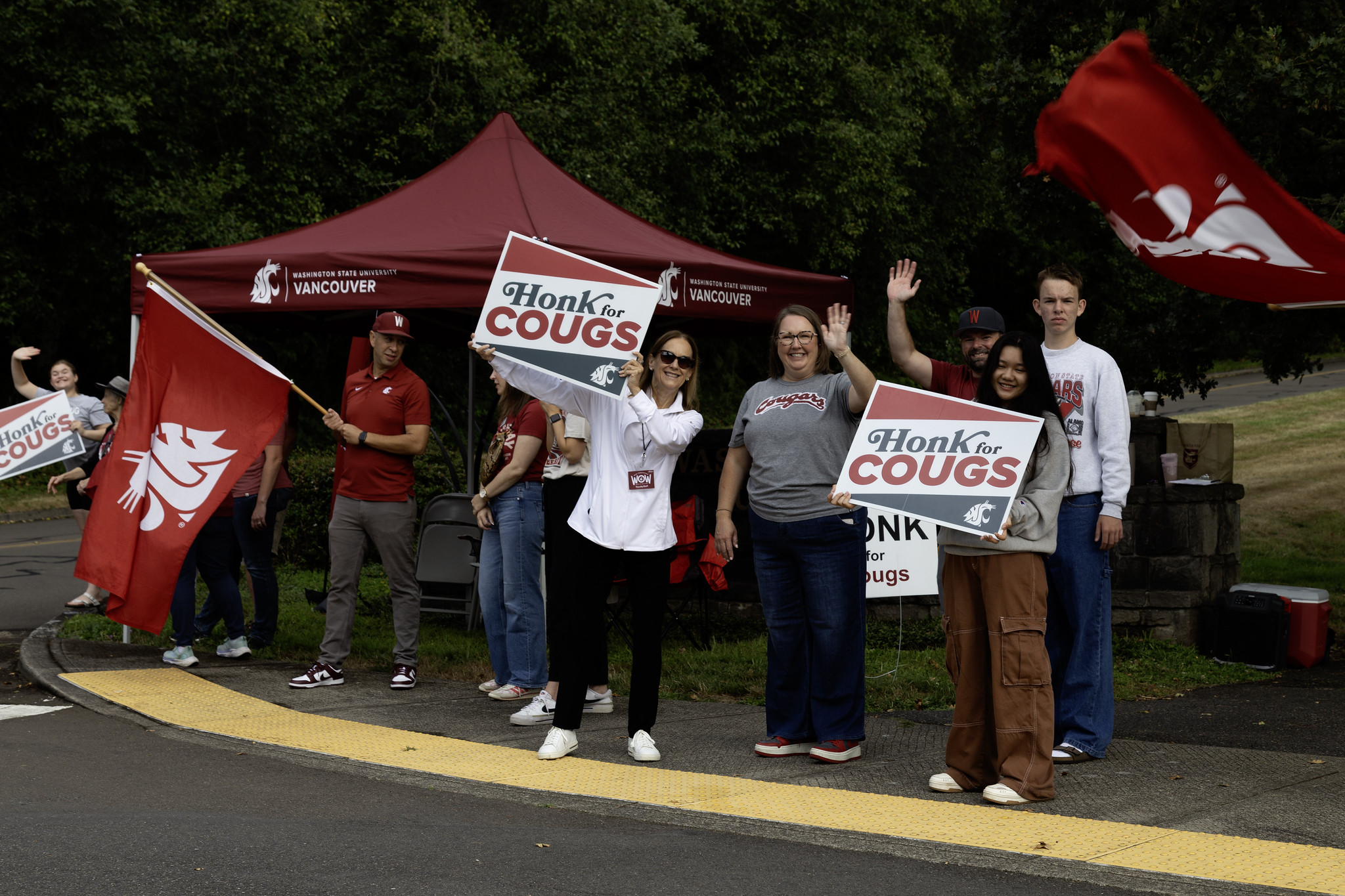 A group of individuals holding signs and banners while gathering outdoors at a WSU Vancouver event