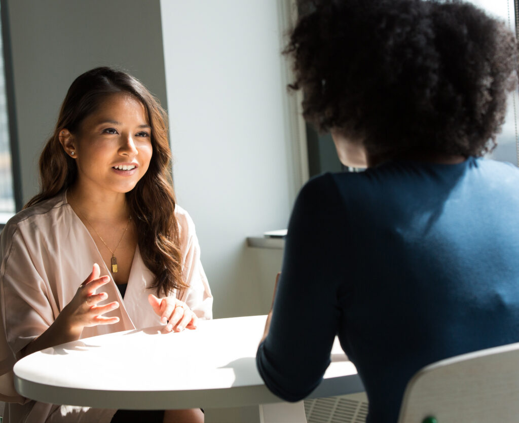 Two professional women engaged in a consultative discussion at a WSU Vancouver meeting