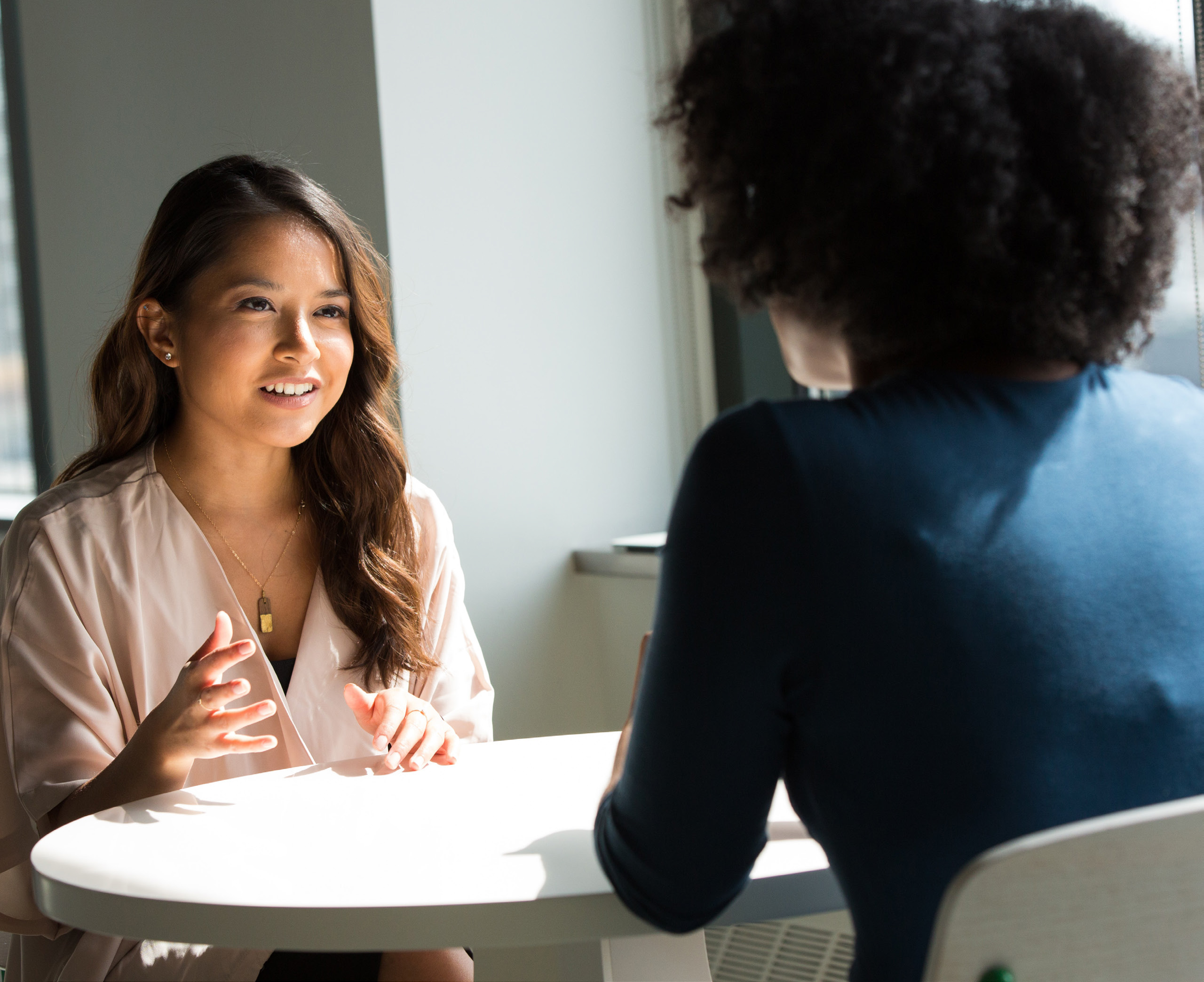 Two professional women engaged in a consultative discussion at a WSU Vancouver meeting