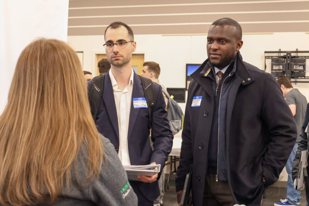 A group of professionals in business attire networking and talking at an event