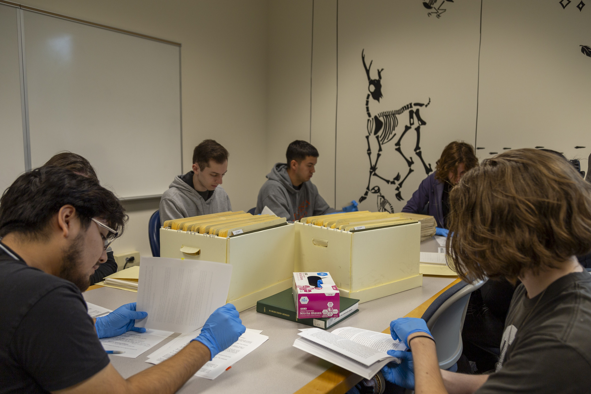 Students working on an art or craft project at a long table indoors