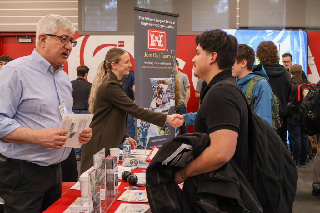 A student networking with an employer at a WSU Vancouver career fair booth