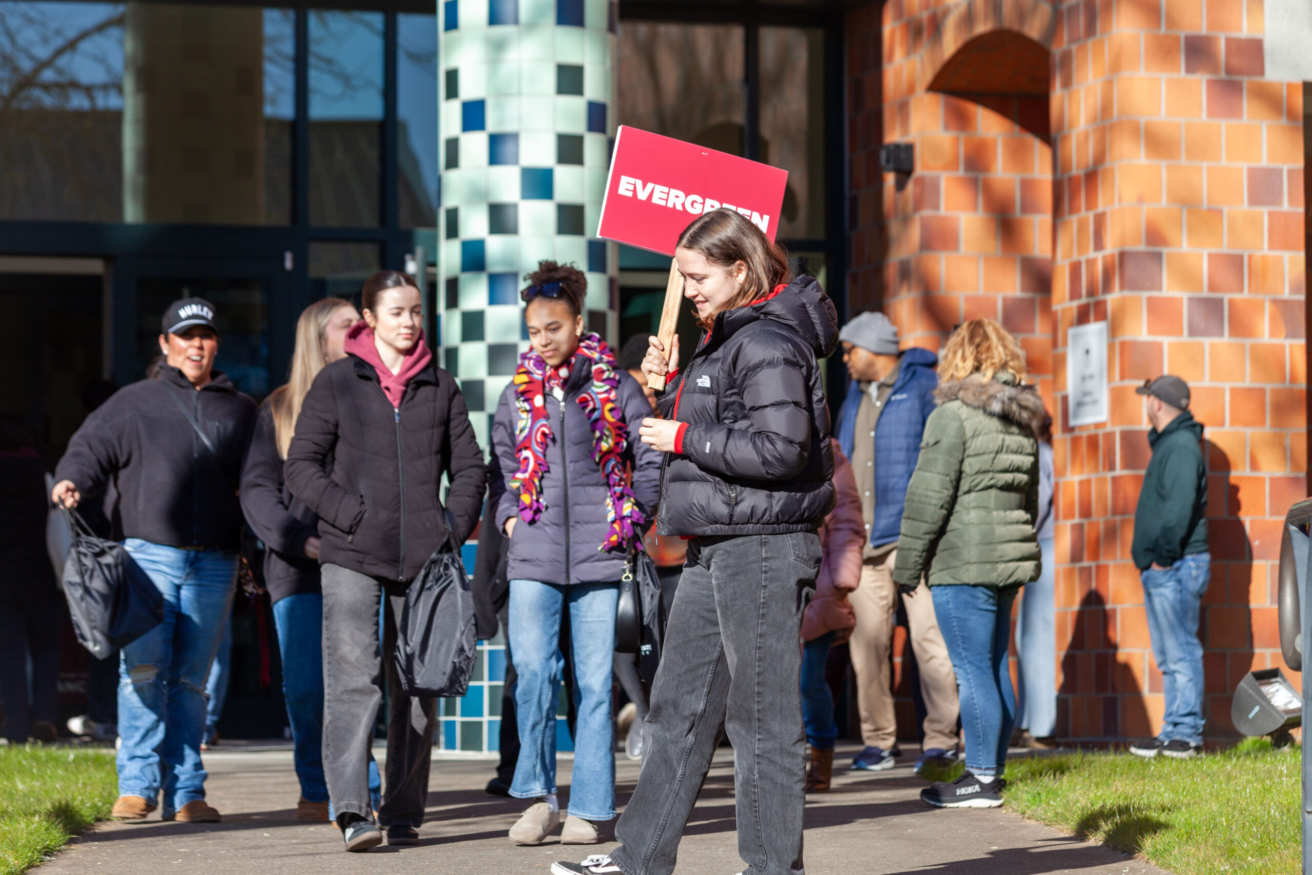 A group of students walking and talking outdoors on a sunny day at WSU Vancouver