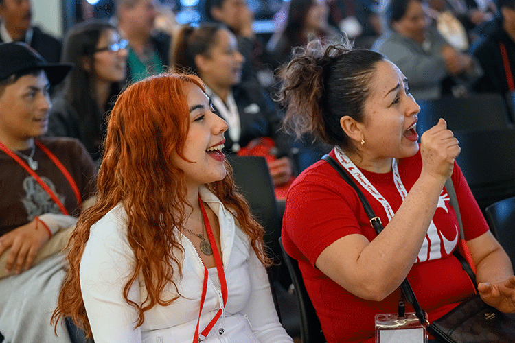 Audience members listening intently during a professional panel presentation indoors