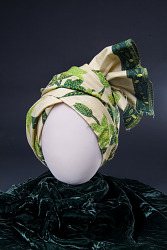 This headwrap dating between 1972 and 1984 was worn by Fath Davis Ruffins, an African American woman in Washington, DC. Ruffins bought the fabric for this headwrap and matching dress, which is also in the Smithsonian collections, at an African shop on Georgia Avenue in Washington, DC. It was made in 1972 but was worn as part of a summer "dress-up" outfit through 1984. Elaborately tied headwraps were worn by young African American women during this period to acknowledge their West African ancestral roots.