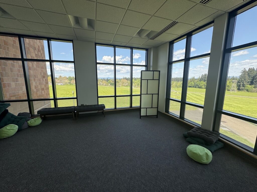 Reflection Room - WSU Vancouver - An indoor fitness studio space with large windows overlooking a scenic campus lawn view