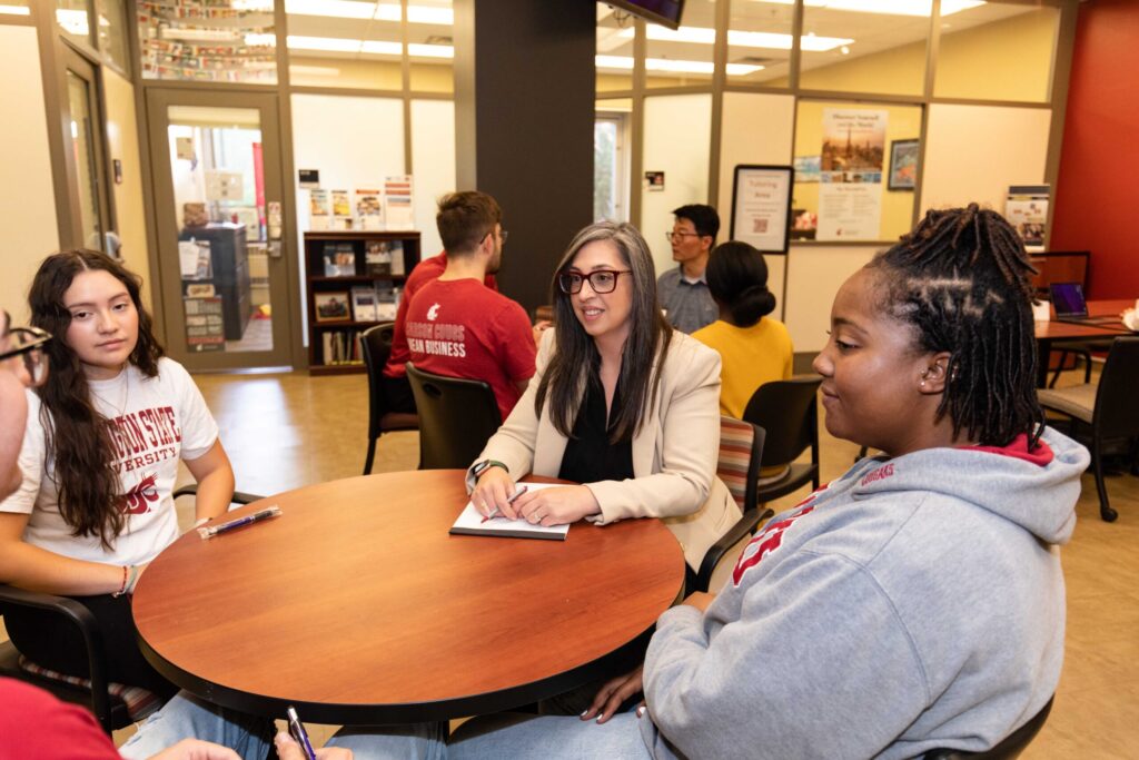Students sitting around a conference table in a modern WSU Vancouver student union lounge