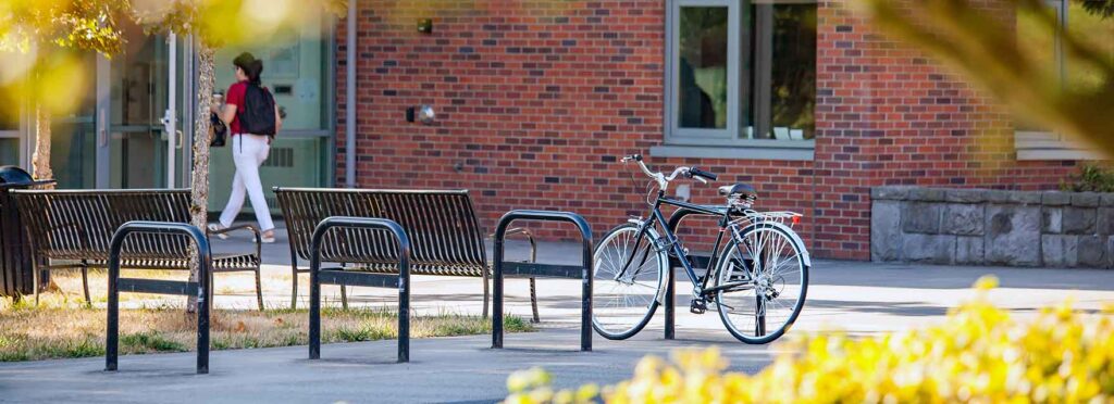 An outdoor bike rack area next to a brick academic building at WSU Vancouver