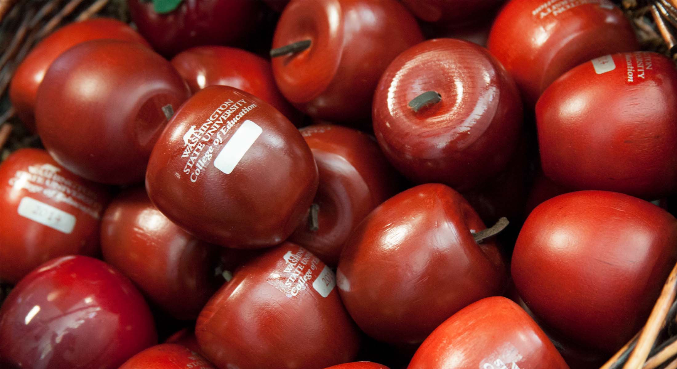 A close-up pile of fresh, shiny red apples gathered together