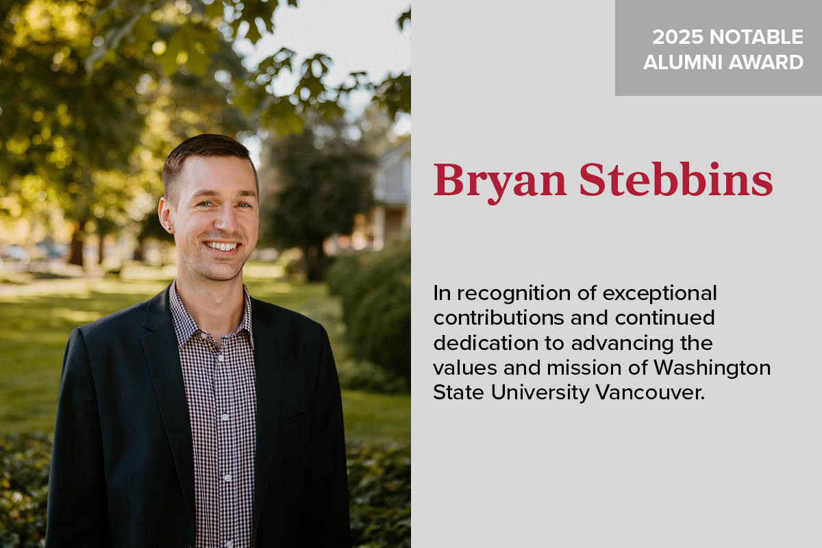 Portrait of a smiling professional man next to a descriptive plaque panel on a wall