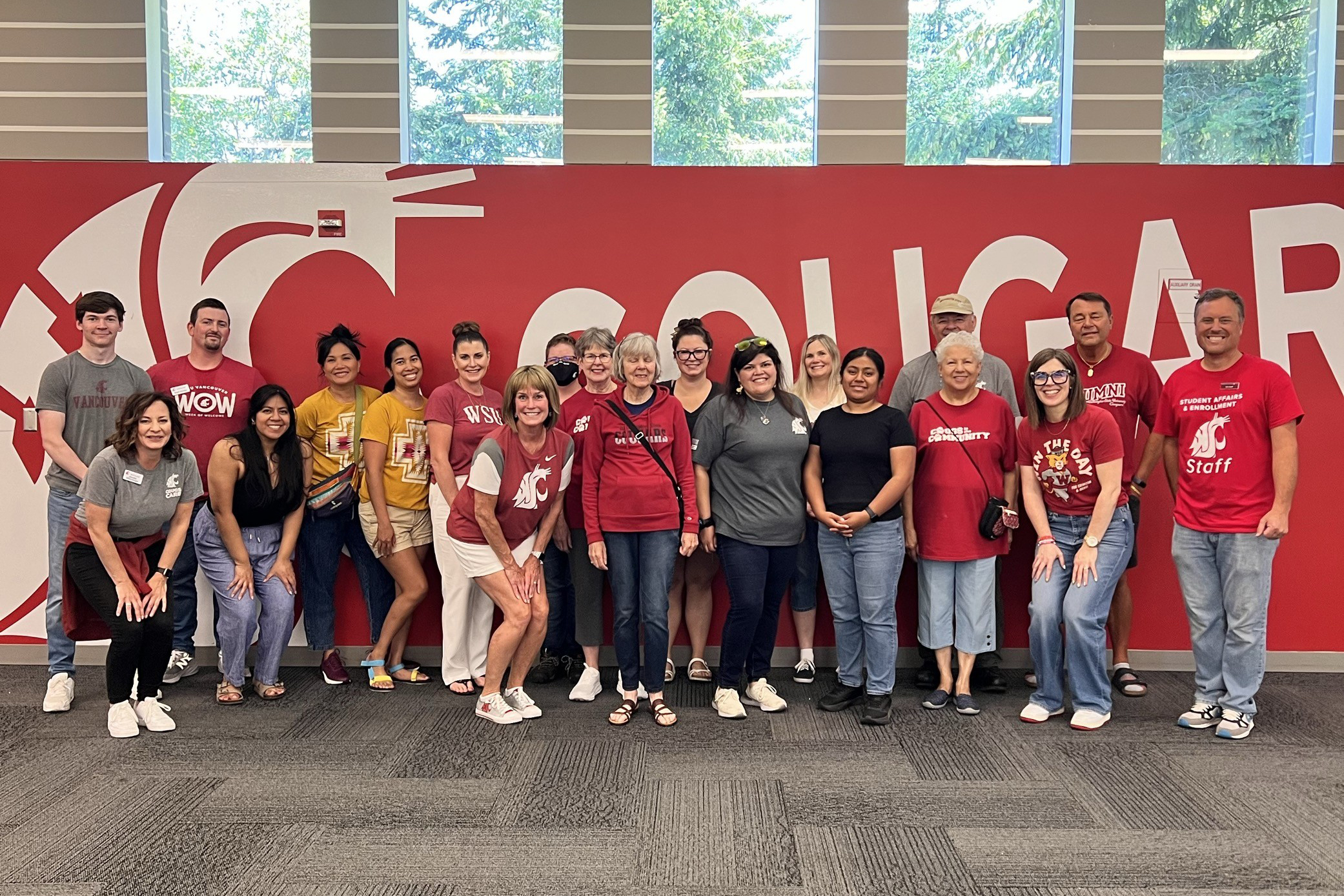 Development and Alumni Relations A large group of student leaders posing together tightly for a photo next to a red wall