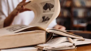 Close-up of an open old hardcover book with pages being turned
