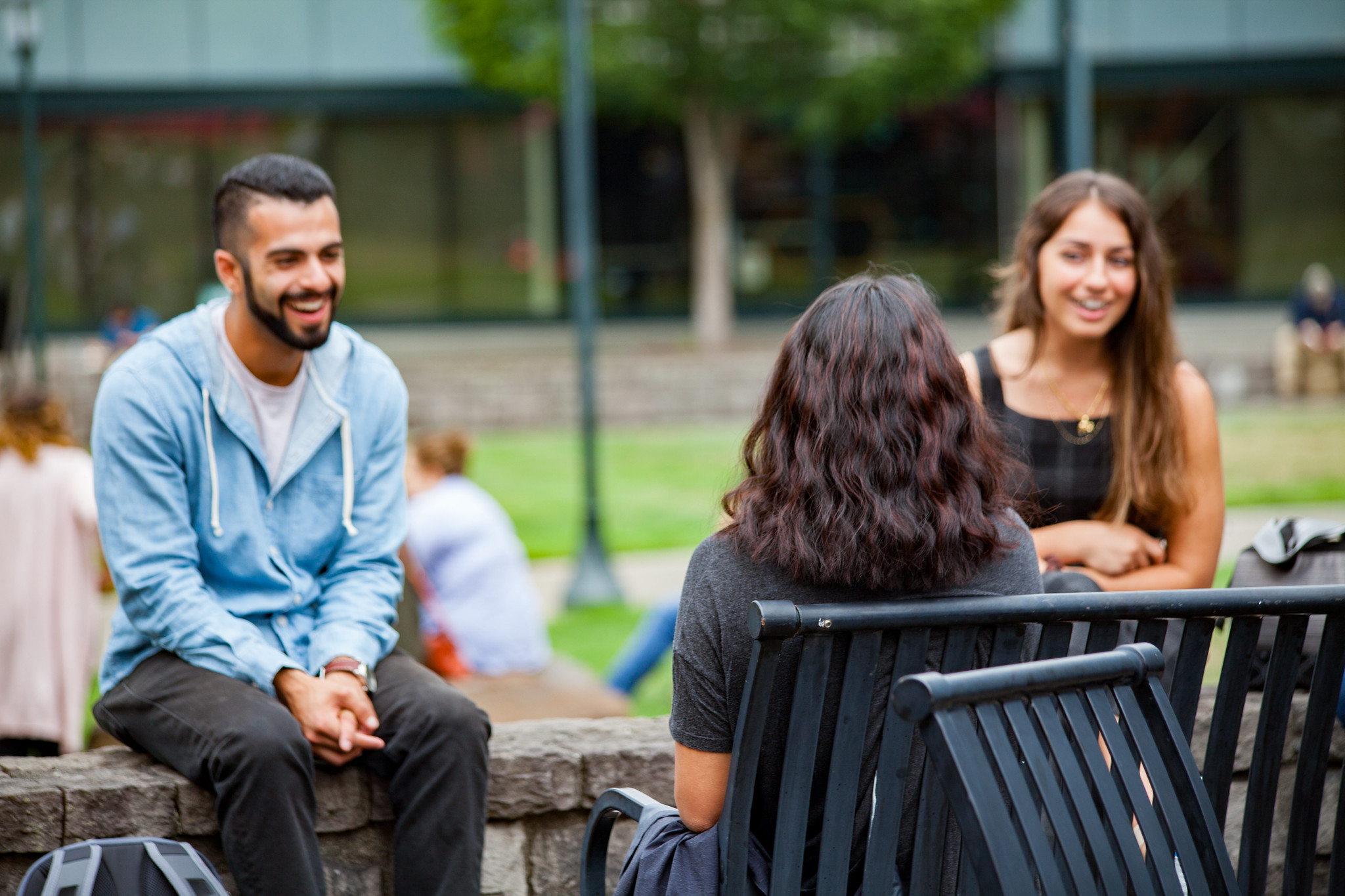 WSU Vancouver students sitting outside the campus Students socializing and chatting outside near campus buildings on a sunny afternoon