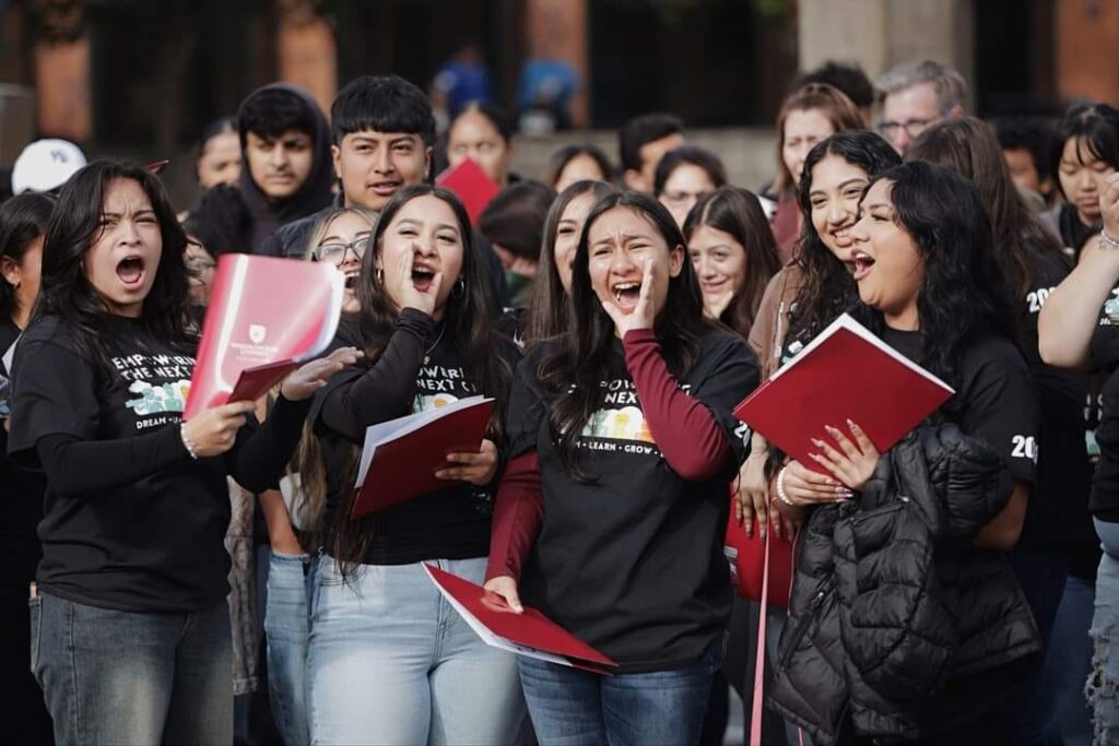 A group of cheering students singing or chanting together at a WSU Vancouver campus event