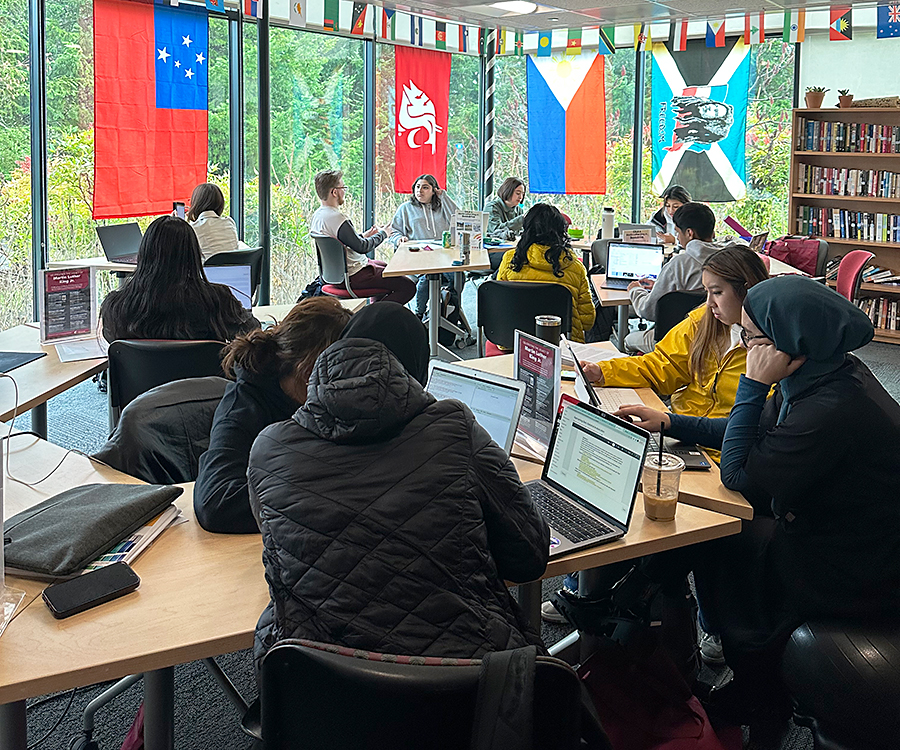 Students collaborating on laptops around shared tables inside a WSU Vancouver computer lab