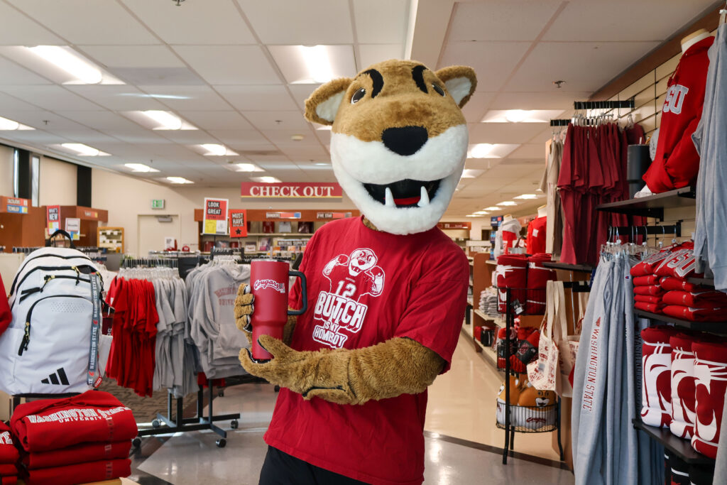 Butch drinking from a WSU cup in the bookie WSU Vancouver Book Store